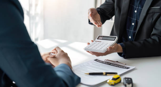 istock Car Insurance document or lease concept the car broker assisting his customer and explaining the detail of the car contact. Car key Buying or selling signing 1493363034