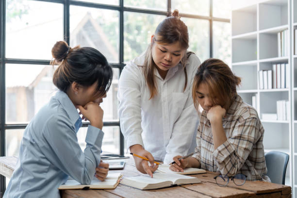 istock Distracted from preparing college project happy young laughing diverse classmates having fun, telling jokes, enjoying carefree pause time together, sitting at table in library 1493364532