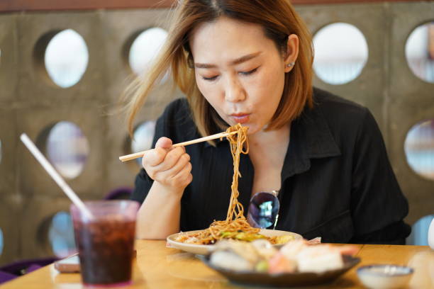 istock Young asian women enjoy eating Yakisoba with using chopsticks 1493364970