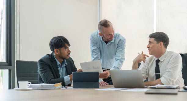 istock Business team discussing online project, showing computer presentation to skilled team leader. Friendly diverse colleagues working in pairs on laptop 1493367012