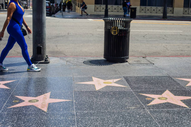 Hollywood, U.S.A. - May 18, 2023. One person, obscured, walks beside the Walk of Fame in blue spandex.