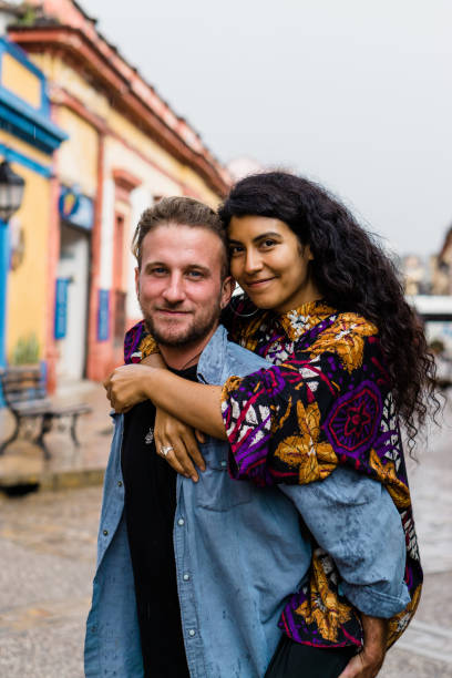 istock Interracial couple of young friends hugging and looking at the camera. 1493380098