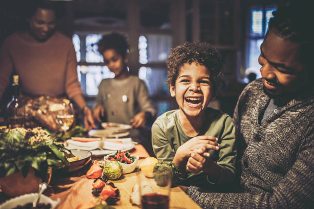 istock Cheerful black boy with his father at dining table. 1493386342