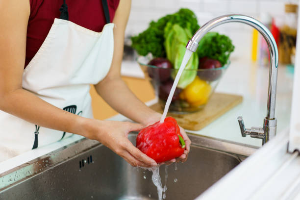 istock Woman washing a vegetables in kitchen. 1493387719