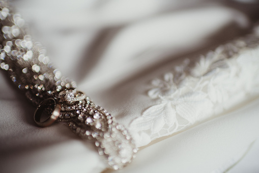 Wedding ring and engagement ring on the belt of the wedding dress