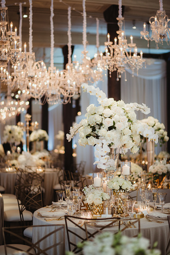 Elegant table settings and chandeliers at a wedding dinner