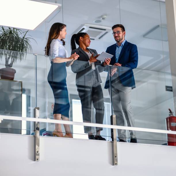 istock Business people leaning against a glass fence and using a digital tablet 1493393193