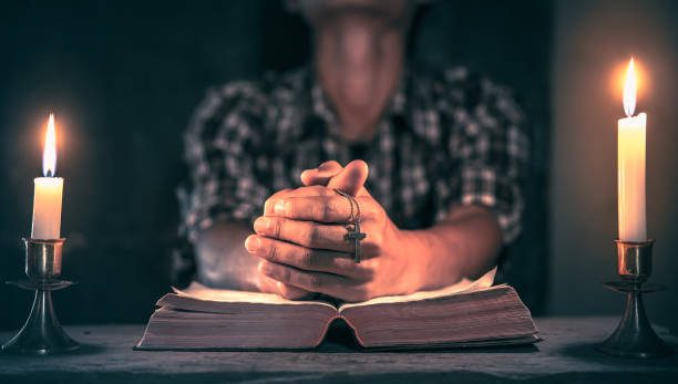 istock Young male praying on bible. christian concept. 1493394728