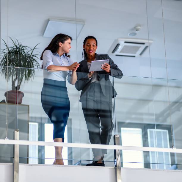 istock Business people leaning against a glass fence and using a digital tablet 1493396155