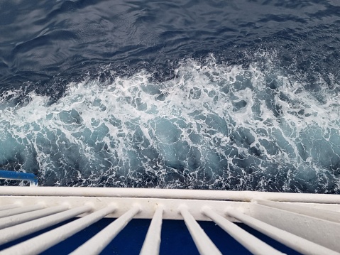 A top view of sea waves foaming, seen from a boat