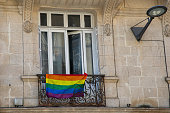 Rainbow colored flag balcony facade on city street in lgbt gay lesbian colors