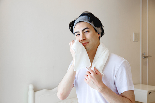 Japanese man using a towel to wipe his face