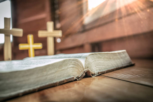 istock Close up of holy Bible with three cross standing at background in window light effect. christian concept. 1493401815