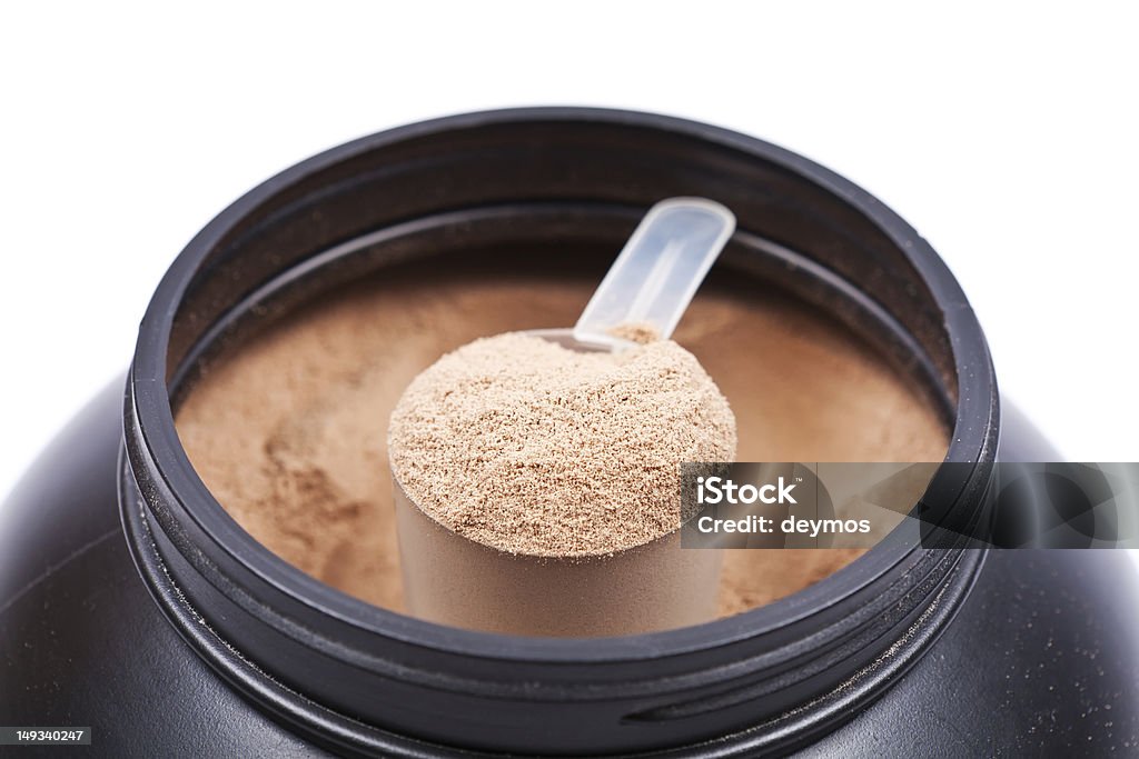 Close-up of a scoop of chocolate protein powder in container Scoop of chocolate whey isolate protein in black plastic containter on white background Black Color Stock Photo