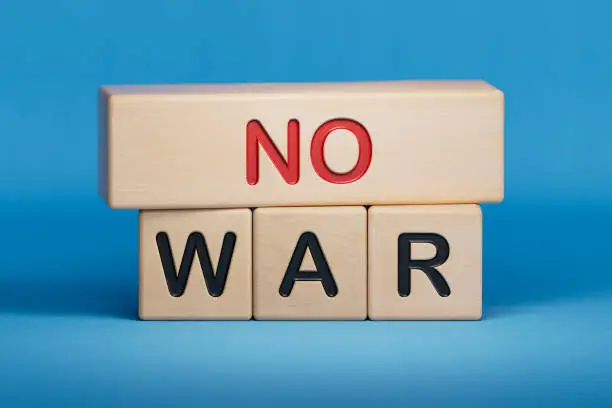 Photo of NO WAR symbol. Wooden blocks with words 'NO WAR'. wooden cubes with the inscription NO WAR.3D rendering on blue background. Wooden cube blocks.