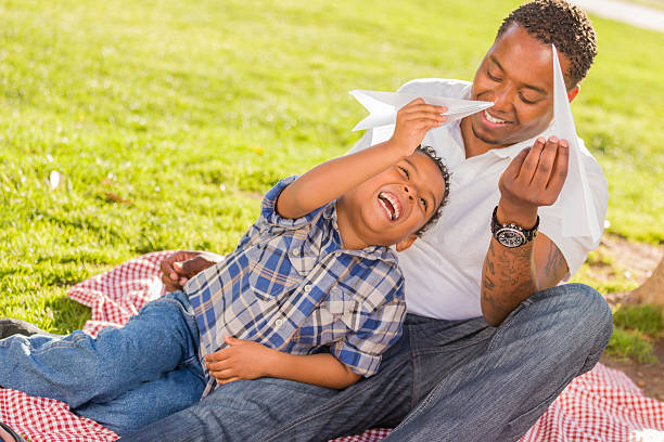 istock Mixed Race Father and Son Playing with Paper Airplanes 149340551