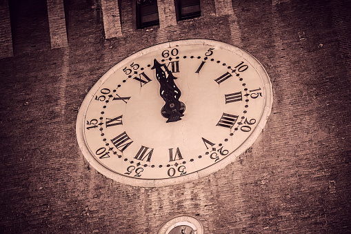 A stunning photo of the clock at Ferrara Castle at night, capturing the elegance and grandeur of the historical building