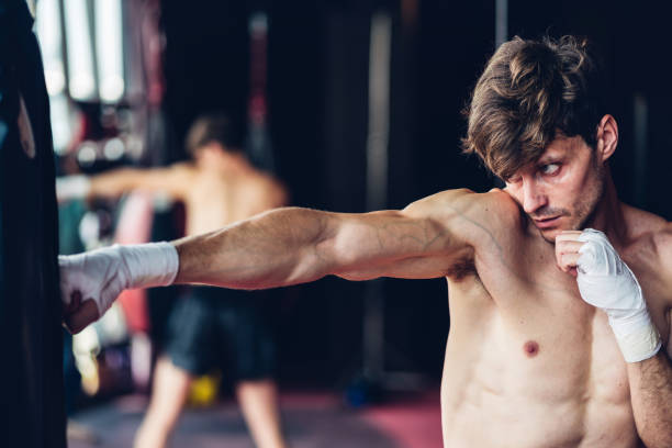 istock Boxer training in Boxing Club. Boxing fighters training at gym. Strong muscular Man practicing box in gym. 1493406272