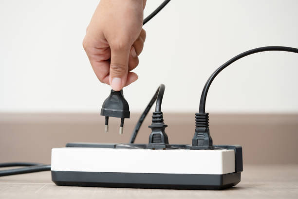 istock Human hand put in or out electric plug in the socket to connect the devices 1493406635