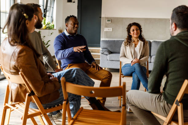 istock Group of people sitting in circle, talking during group therapy 1493413859