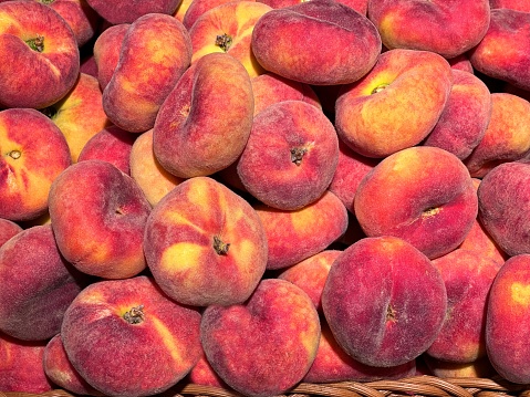 Flat peach fresh fruits in the basket.