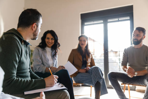 istock Male therapist writing notes on the clipboard during a group therapy session 1493414772