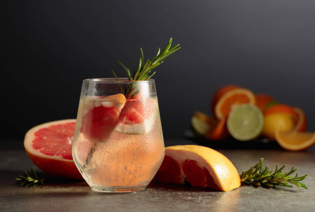 istock Cocktail gin tonic with ice, rosemary, and grapefruit on a stone table. 1493416038