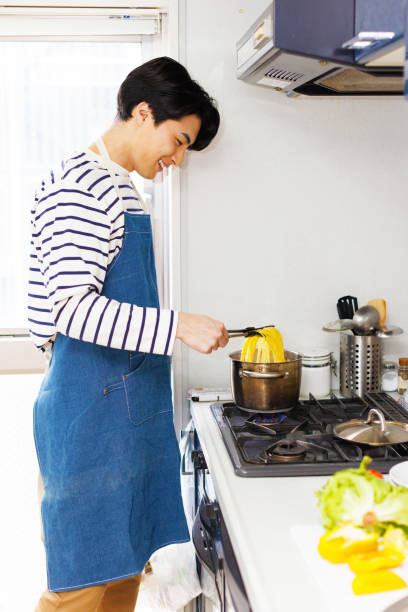 istock Japanese man in apron cooking pasta at kitchen 1493421025