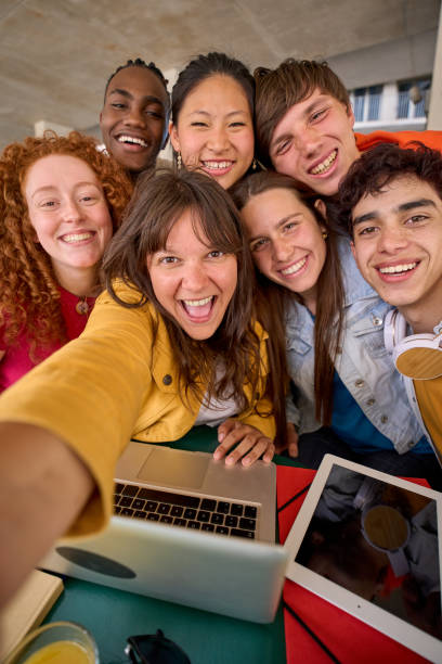 Vertical selfie mobile phone multiracial group of students gathered in hall of university building. stock photo