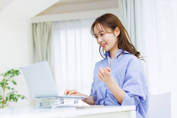 日本の女性自宅で - オンライン診療 スマホ 日本人 ストックフォトと画像
