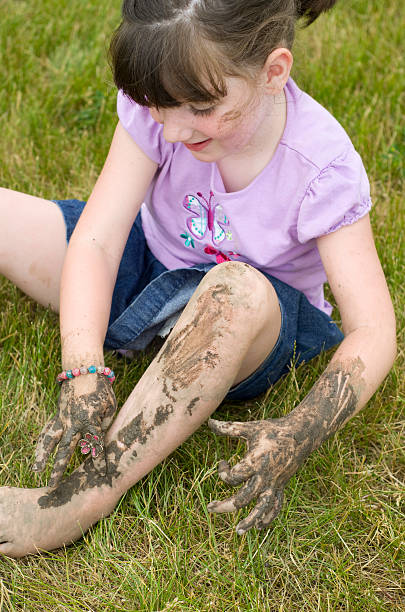 little girl makes a mess with mud