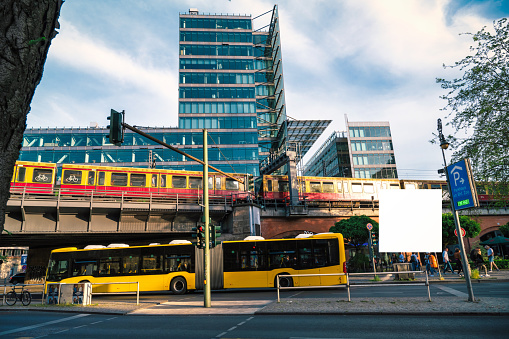 yellow bus under and and subway train on railroad bridge in west Berlin in Berlin Charlottenburg near Train Station Zoologischer Garten