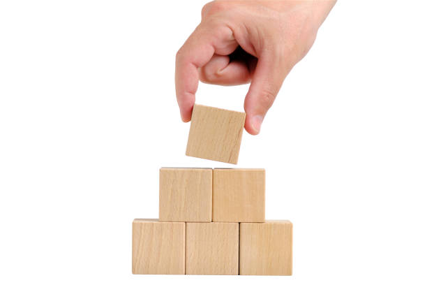 istock Pyramid of wooden cubes is completed with help hand.Concept of development. 1493426981