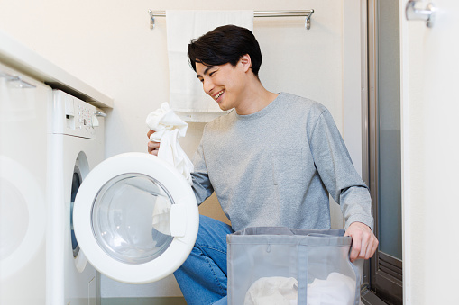 Japanese man doing laundry at home
