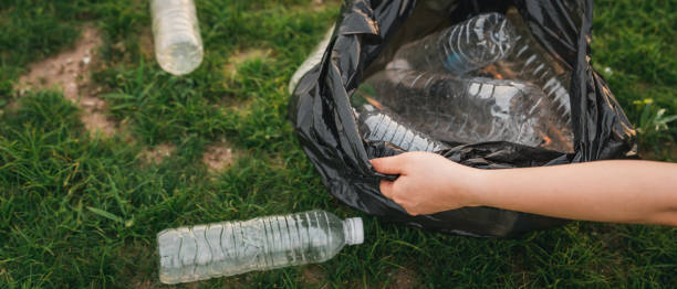 istock Close up hand collects garbage plastic in a park. A volunteer cleaning plastic bottle on a grass. Environment, recycle and protection concept. 1493431742