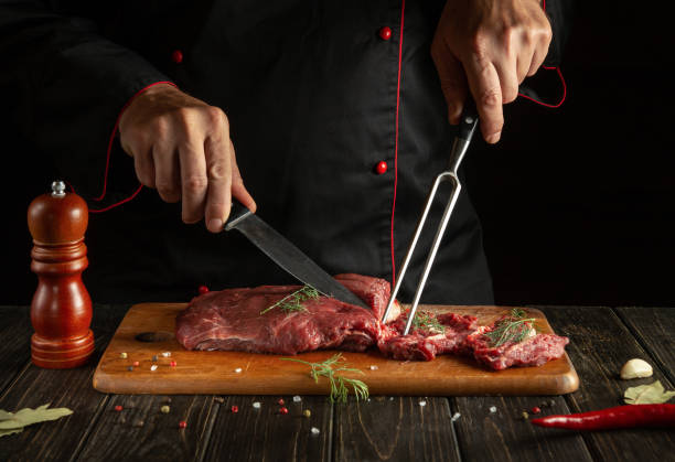 istock Butcher or chef preparing raw fresh beef meat on cutting board before baking or barbecue. Recipe idea for a restaurant or hotel 1493438489