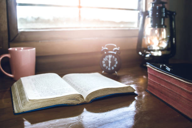 istock open bible with cup of coffee on wooden table with window light in morning devotion. 1493440231