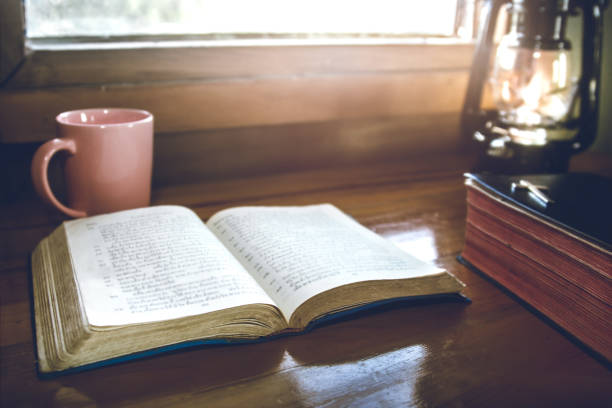 istock open bible with cup of coffee for morning devotion on wooden table with window light 1493440234