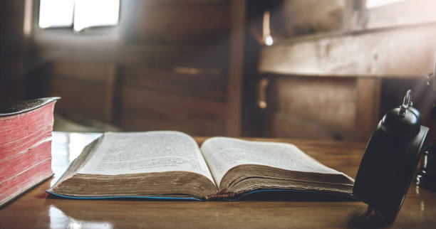 istock Open Bible with  the cross on wooden table. 1493440238
