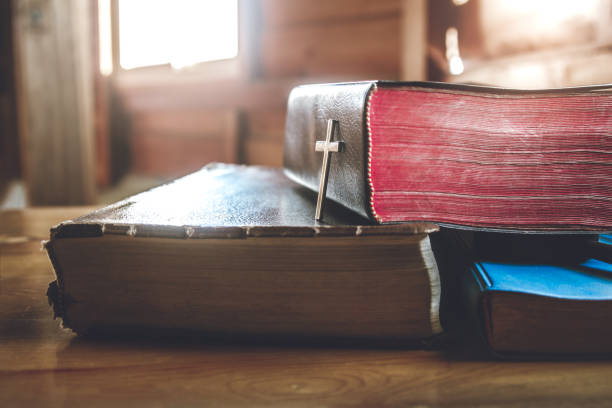 istock focus christian cross place on holy Bible with window light. 1493440305