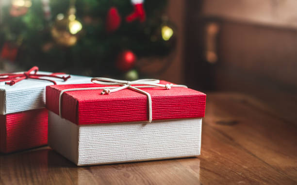 istock Red gift box on wooden table at Christmas tree and lights background.Christmas concept 1493440313