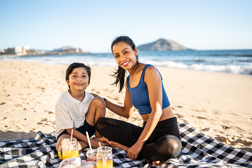 Portrait of mother and son having picnic on the beach