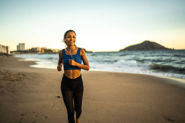 istock Young sporty woman running on the beach 1493446521