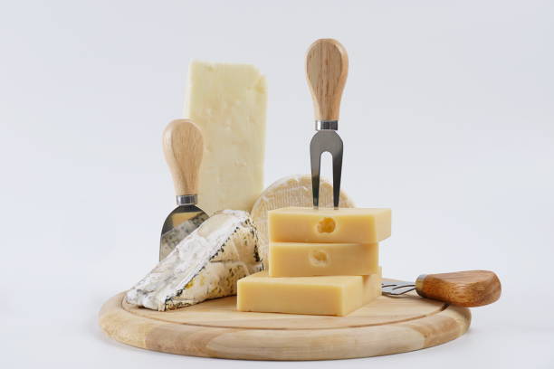 Various types of cheese on wooden cutting board
