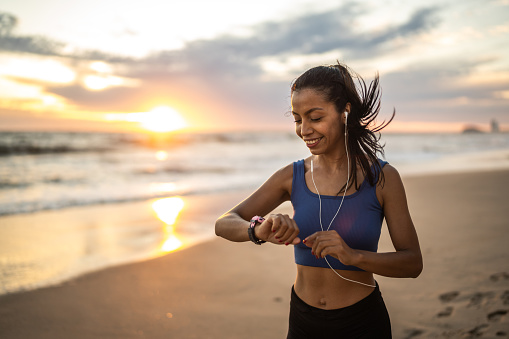 Young sporty woman running on the beach