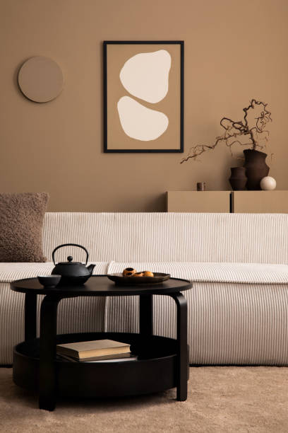 istock Creative composition of living room interior with mock up poster frame, modular sofa, round coffee table, pitcher, vase with branch, brown sideboard and personal accessories. Home decor. Template. 1493446878