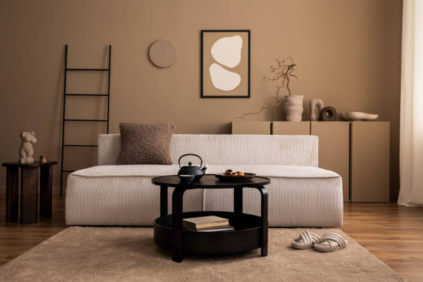 istock Warm and cozy living room interior with mock up poster frame, modular sofa, black coffee table, ladder, beige rug, vase with branch, sculpture, slippers and personal accessories. Home decor. Template. 1493446892