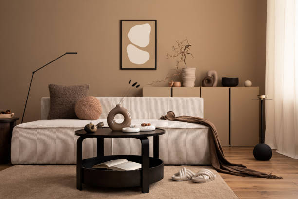 istock Interior design of cozy living room interior with mock up poster frame, modular sofa, round coffee table, vase with dried flowers, brown plaid, lamp and personal accessories. Home decor. Template. 1493446896