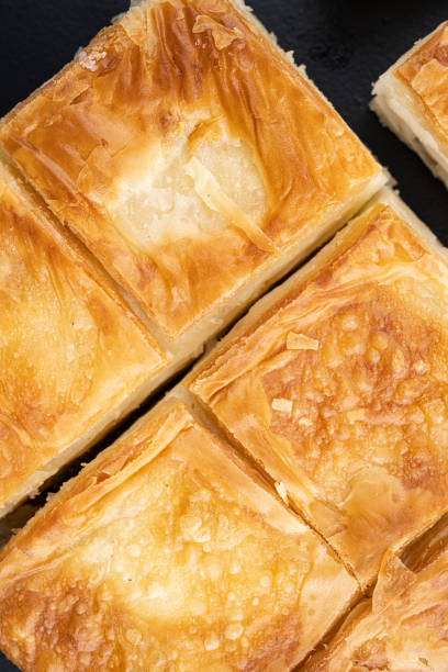 istock Turkish Pastry for Breakfast Su Boregi, top view flat lay, on black dark stone table background 1493448378