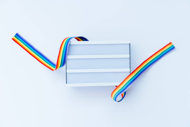 istock Top view White light box mockup with rainbow LGBT ribbon on a light background isolated. Copy space for text or design. Pride month tape symbol. Gender equality, lgbtq concept. Selective focus. 1493450715